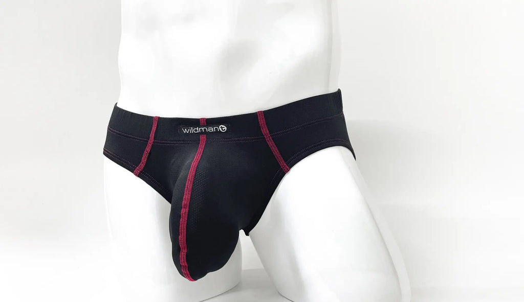 Black pouch brief with red contrast stitching and Wildman logo on the waistband, modeled on a white mannequin.