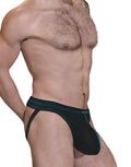 Side view of a man wearing a black jockstrap with a spacious front pouch and prominent blue contrast stitching.