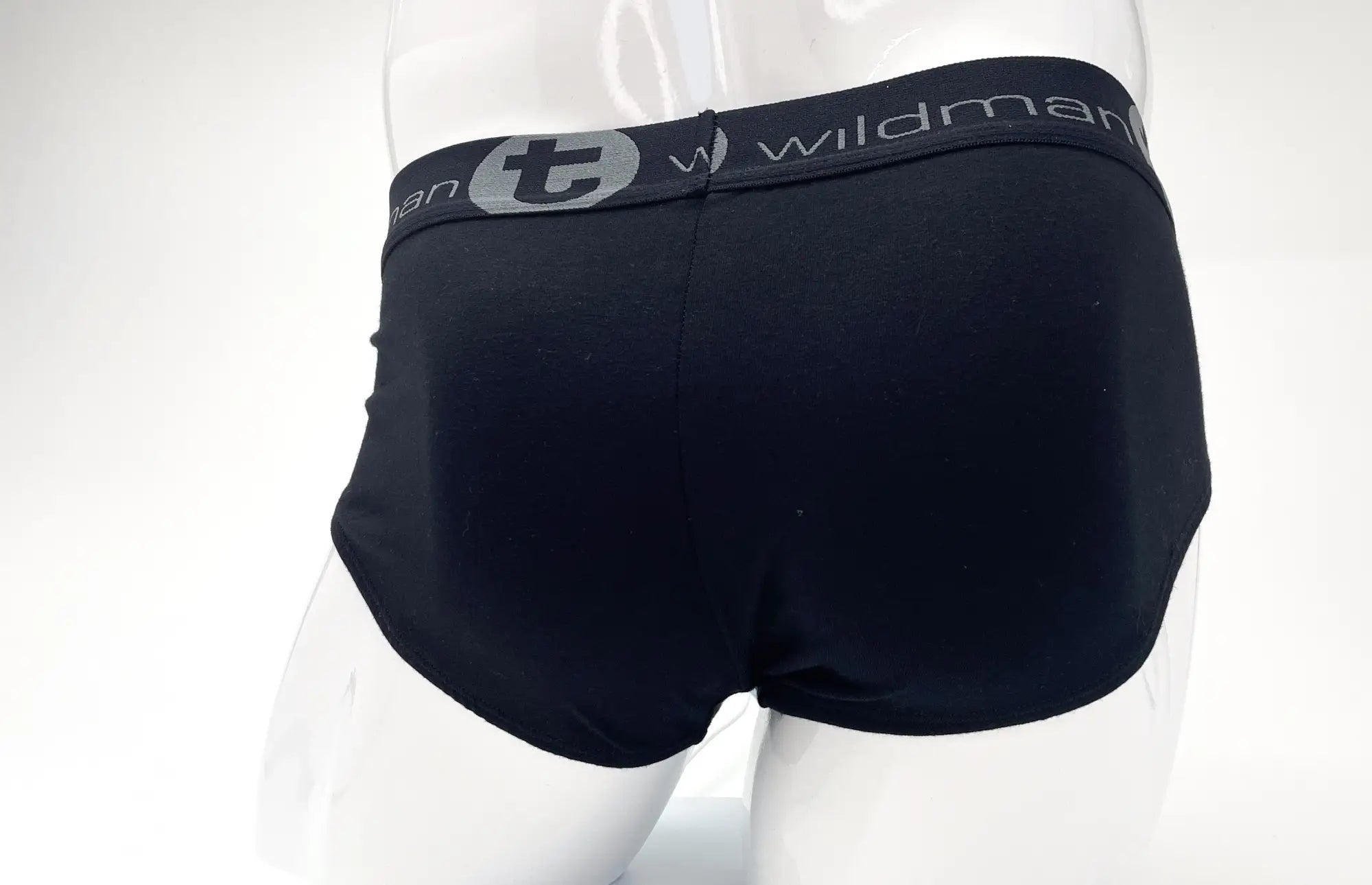Black stretch cotton briefs on a mannequin, featuring a grey waistband with "Wildman" logo text and a circular "t" icon.