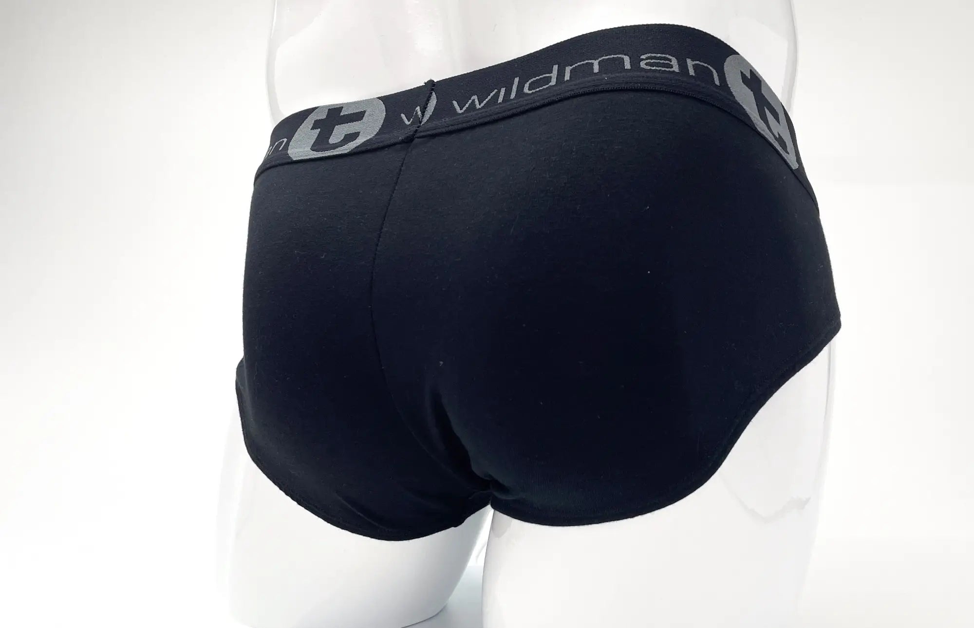 Black stretch cotton brief on a mannequin, featuring a grey branded waistband with the text "wildman" and a T logo.