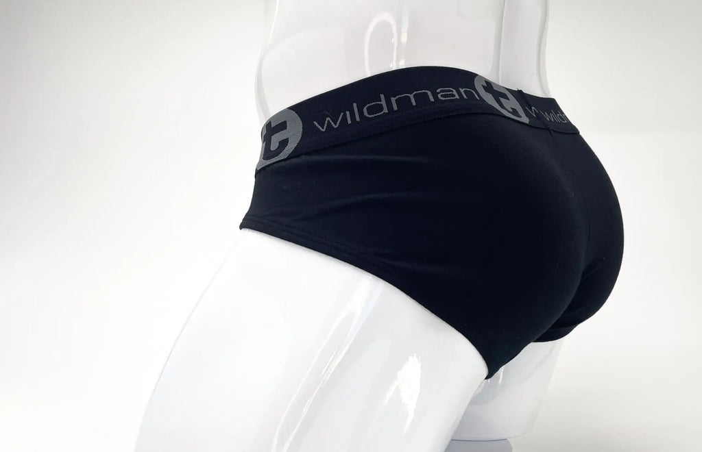 Black stretch cotton brief on a white mannequin, featuring a wide grey elastic waistband with the Wildman T logo.