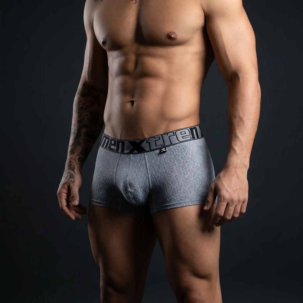 Muscular man wearing Xtremen 51478C gray microfiber jacquard trunks with branded waistband, dramatic studio lighting