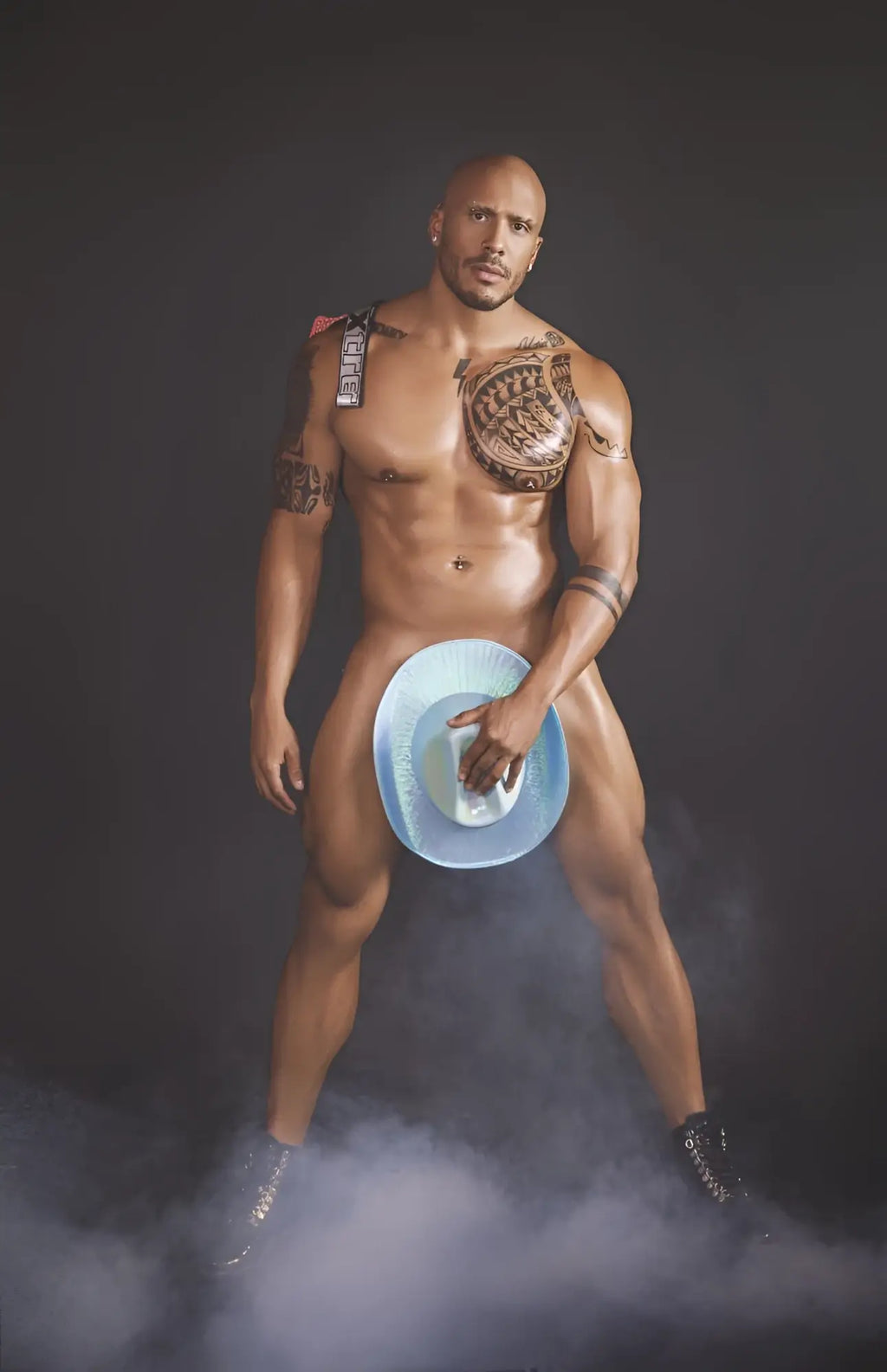 A muscular man holding a blue cowboy hat with white interior wearing a red xtremen 91128 snake print jockstrap