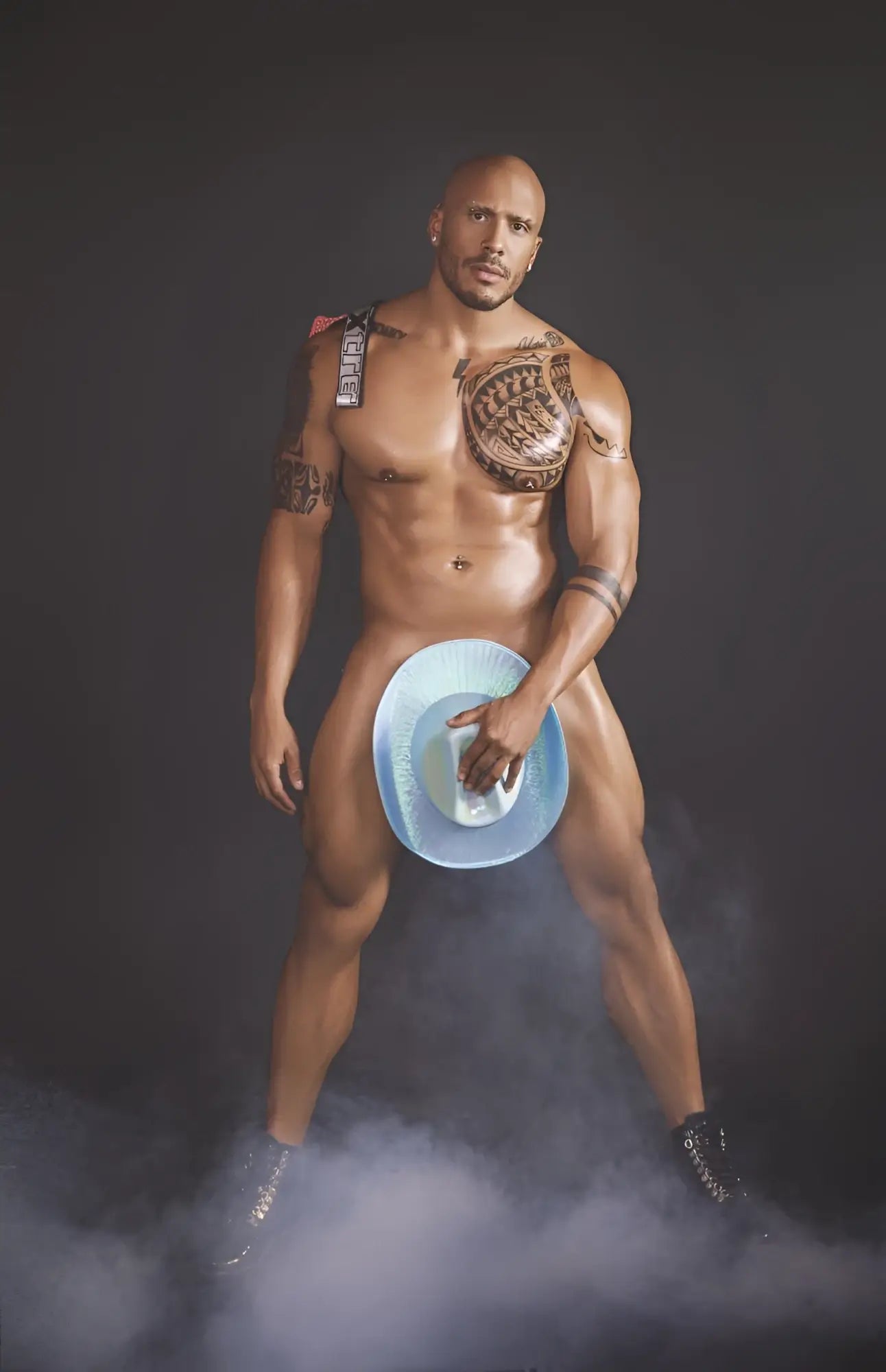 A muscular man holding a blue cowboy hat with white interior wearing a red xtremen 91128 snake print jockstrap