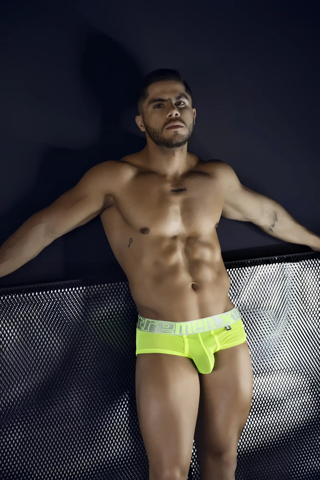Bright neon yellow microfiber briefs with a white ere elastic waistband featuring black lettering