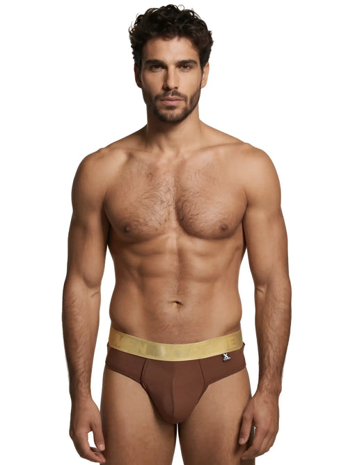 Model wearing brown Xtremen thongs with a metallic gold logo waistband.
