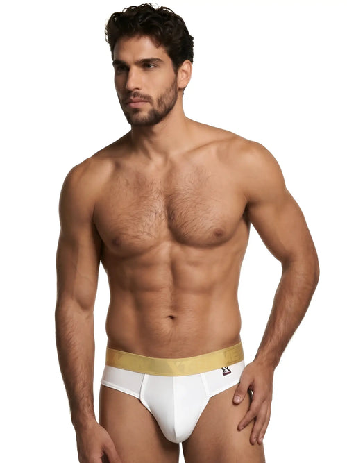 Xtremen white thongs with a metallic gold branded waistband worn by a muscular man.