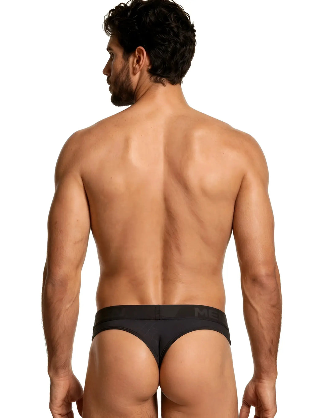 Rear view of a man wearing black Xtremen thongs with a subtle geometric pattern and branded waistband.