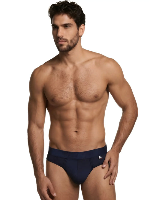 Xtremen men’s navy blue thong with a branded elastic waistband on a fit model.