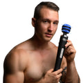 A shirtless man holding a black and blue Zeus Electrosex Blue-Arc E-Stim vibrating wand with electric arc effects.
