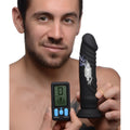 A man holding a black Zeus Electrosex E-Stim Pro 5x vibrating dildo with a digital remote control.