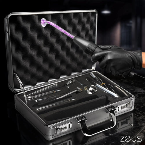 Zeus Electrosex Ultimate Edition Violet Wand set in a silver case with various glass attachments and active electrical glow.
